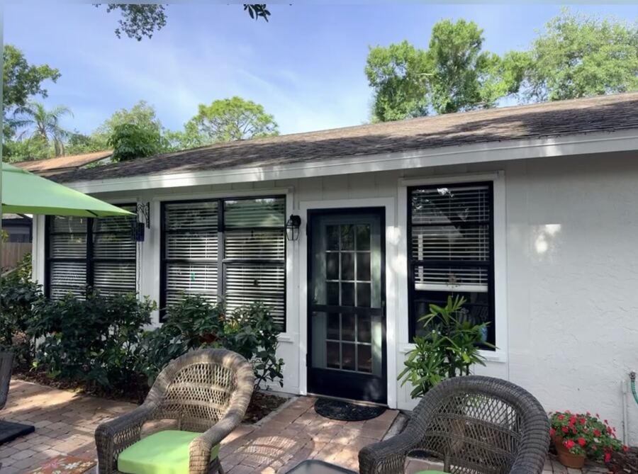 Repainted white cottage exterior with black-trimmed windows and door