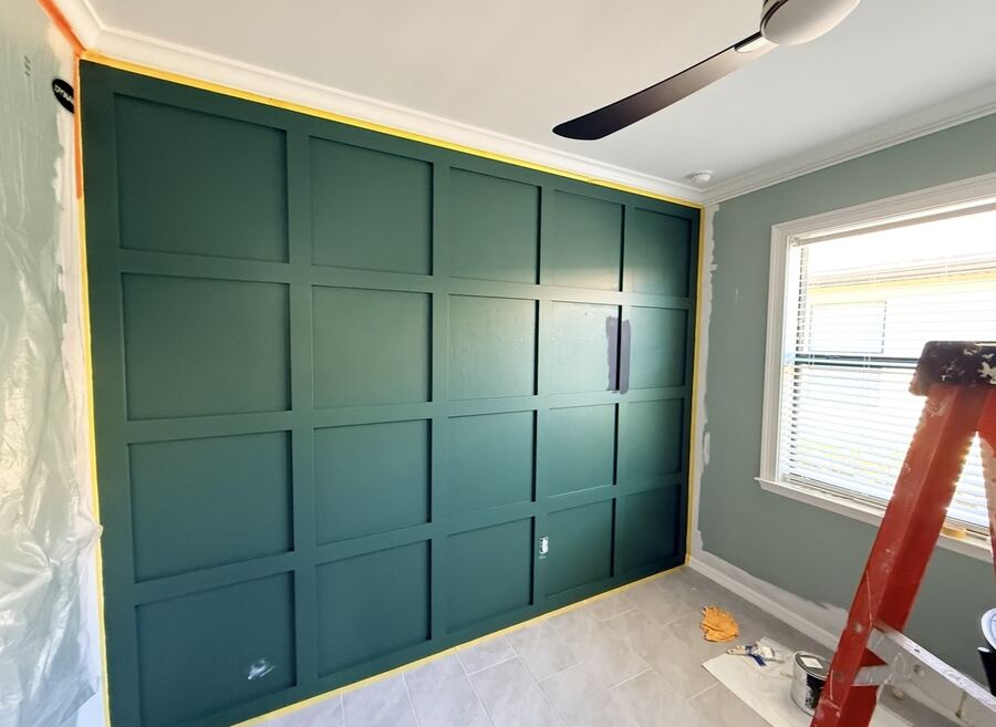 Hunter-green board-and-batten accent wall during installation
