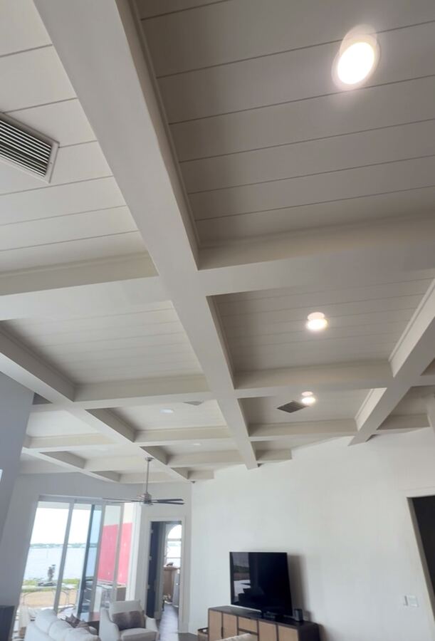 White-painted plank ceiling with beams in a modern living room