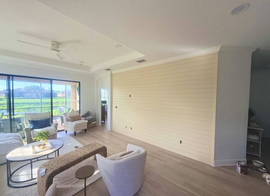 Painted cream shiplap accent wall in a coastal living room