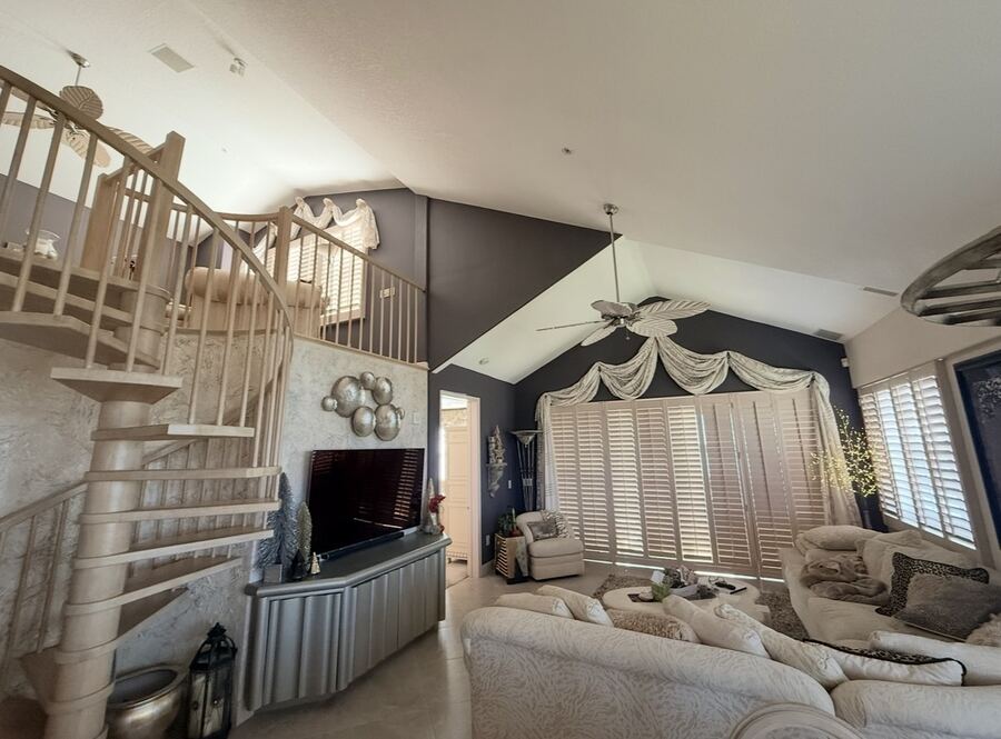 Living room repaint with deep navy walls and spiral staircase
