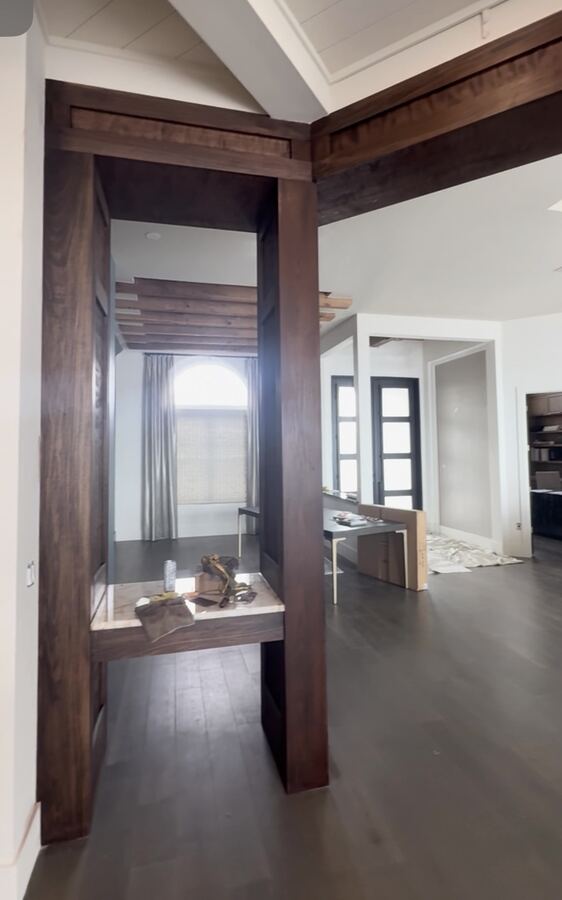 Walnut-stained wood beams and columns in a home entryway