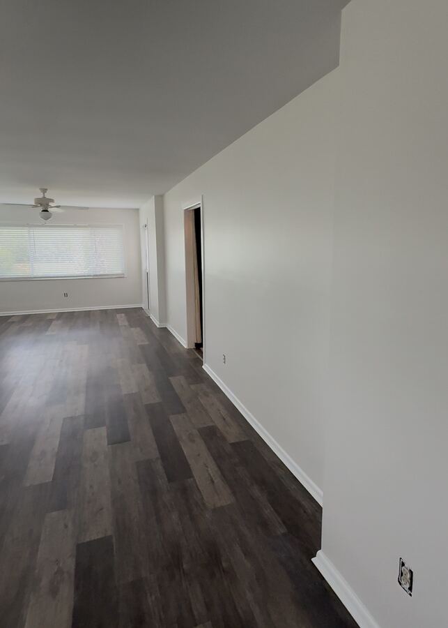 Crisp white walls after an interior repaint with dark wood floors