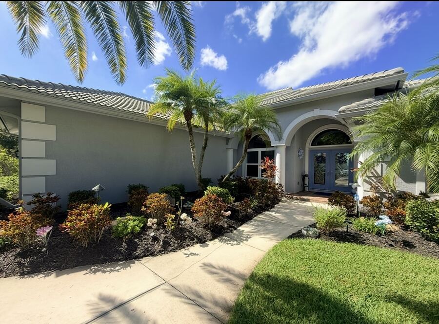 Gray-green exterior repaint with arched entry and palm landscaping