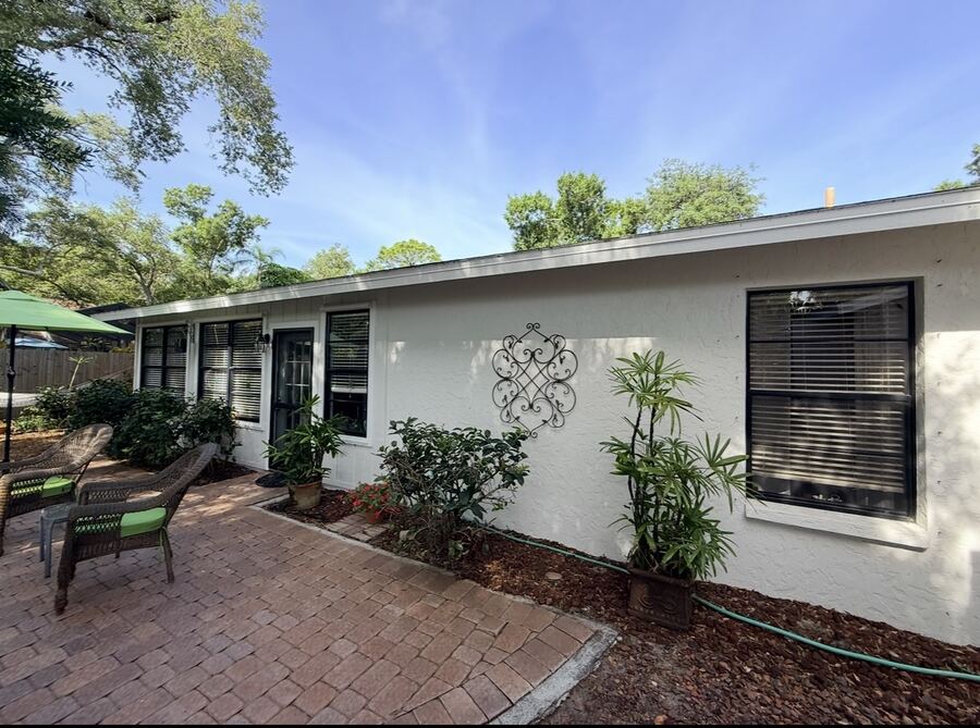 Repainted white cottage rear exterior with brick patio