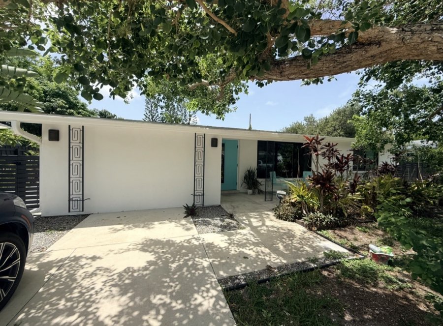 Repainted mid-century home exterior with teal front door accent