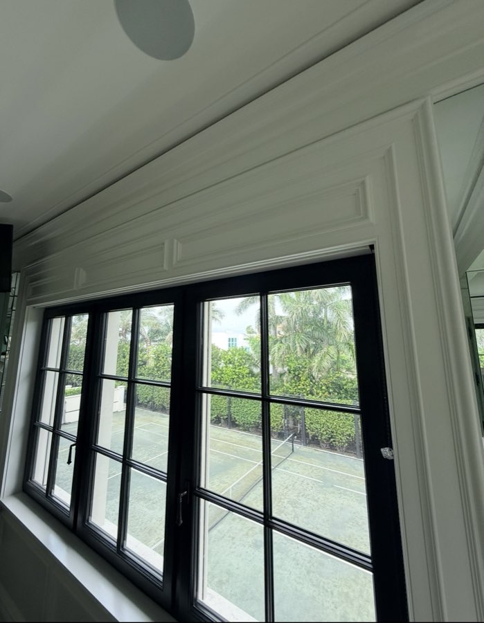 Painted crown molding and window trim overlooking a private tennis court
