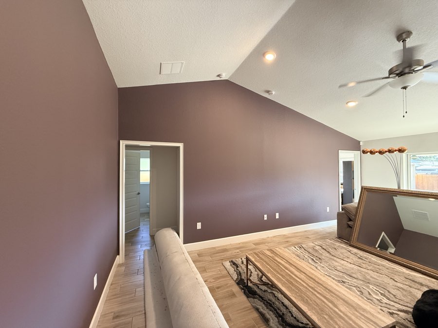 Vaulted living room with a deep mauve accent wall